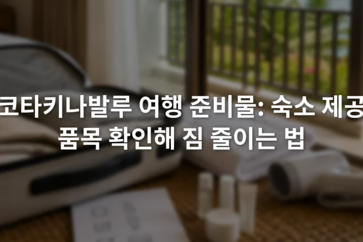 여행 가방 옆에 수건과 헤어드라이어, 세면용품 확인표가 놓인 장면
