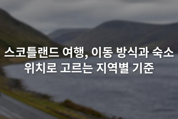 호수와 완만한 산 사이 도로를 따라 이동하는 차량과 흐린 하늘
