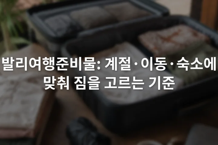 여권 케이스와 얇은 옷, 접이식 우산, 충전 케이블이 열린 여행가방 옆에 놓인 장면