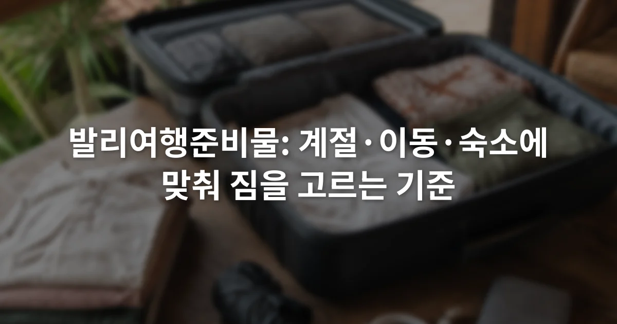 여권 케이스와 얇은 옷, 접이식 우산, 충전 케이블이 열린 여행가방 옆에 놓인 장면