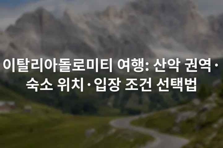 초록빛 계곡 위로 솟은 회색 돌로미티 암봉과 굽은 산길
