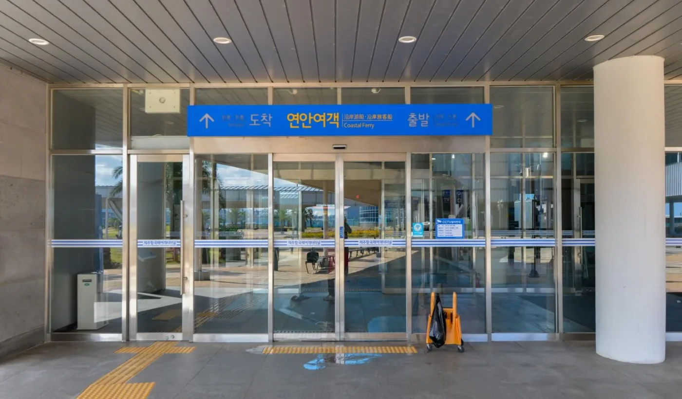 제주항 국제여객터미널 연안여객 출입구, 도착·출발 안내 표지와 유리문