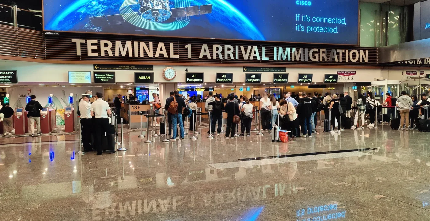 싱가포르 창이공항 1터미널 도착 입국 심사장의 심사대와 줄을 선 여행자들