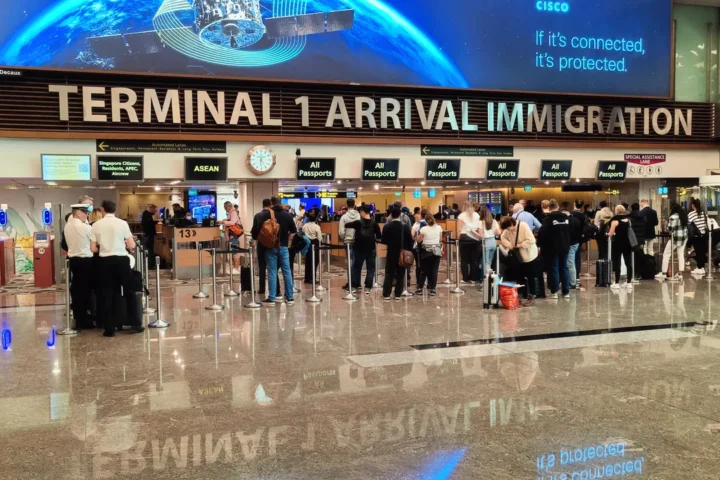 싱가포르 창이공항 1터미널 도착 입국 심사장의 심사대와 줄을 선 여행자들